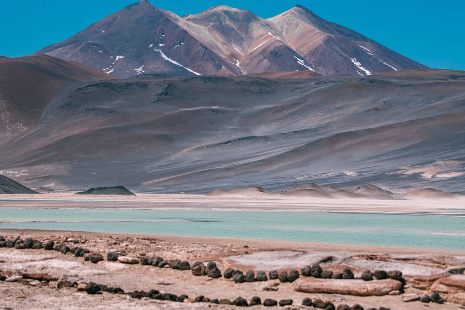 Lagoa turquesa aos pés de montanhas coloridas do altiplano