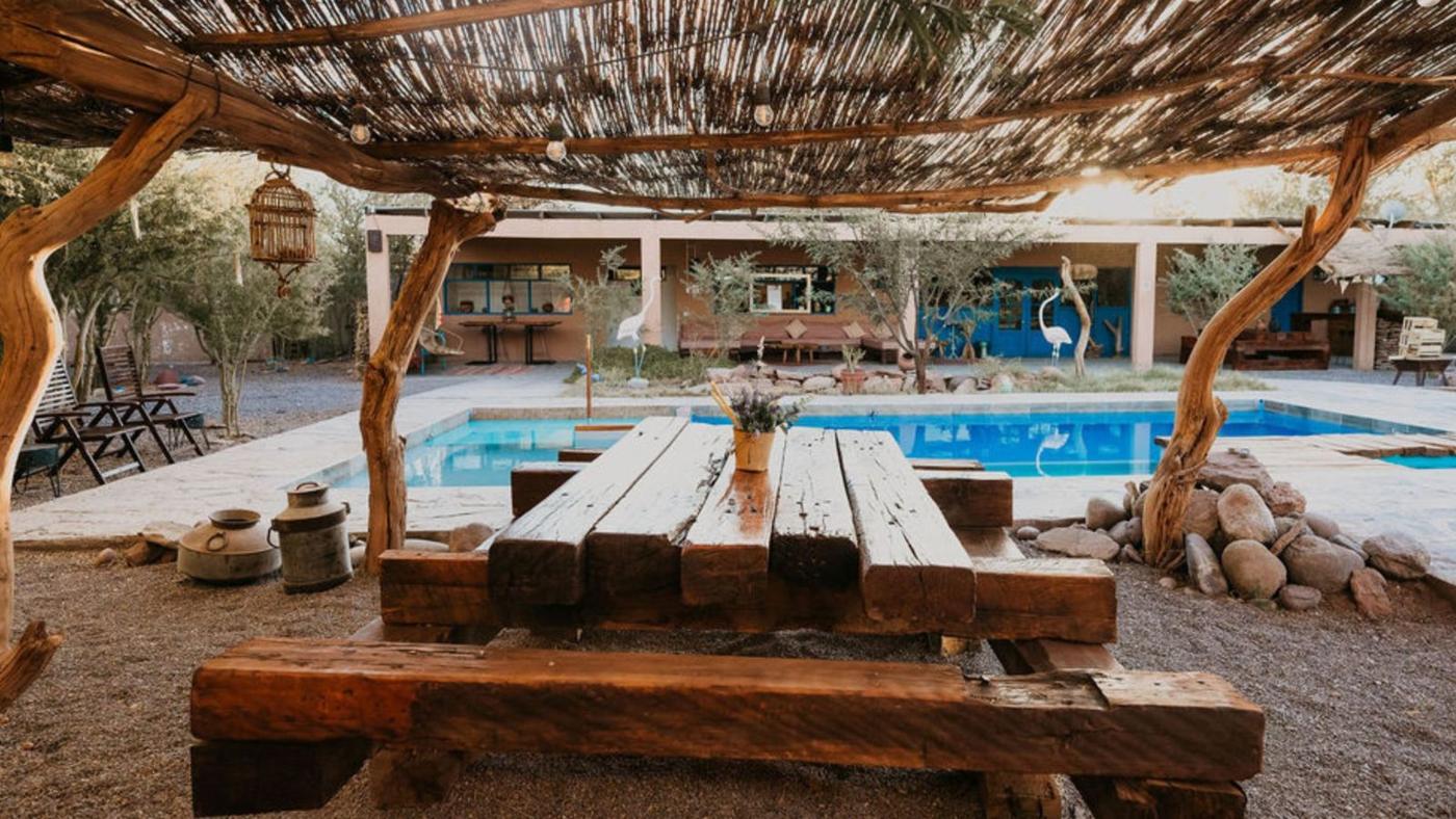 Piscina vista sob o pergolado de totora ao entardecer