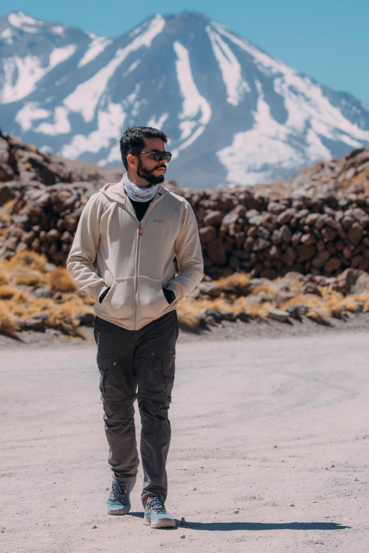 Marcelo caminhando em uma estrada de terra com vulcão nevado ao fundo